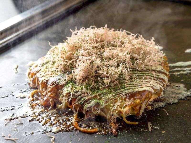 Okonomiyaki, hay bánh xèo Nhật Bản, là món bánh áp chảo với nhiều nguyên liệu như bắp cải, hải sản, thịt ba chỉ, được phủ sốt okonomiyaki, sốt mayonnaise, bột rong biển và cá ngừ bào katsuobushi.